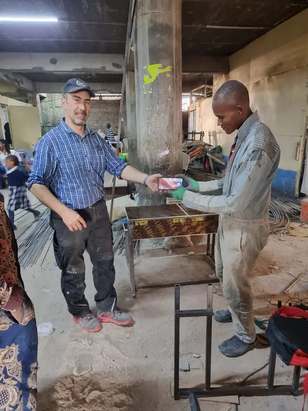 Un profesor de la Integritas îi strânge mâna unui meșter, în atelier